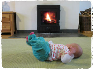 The PFS baby enjoys the warmth from our wood burning stove in Sycamore Cottage